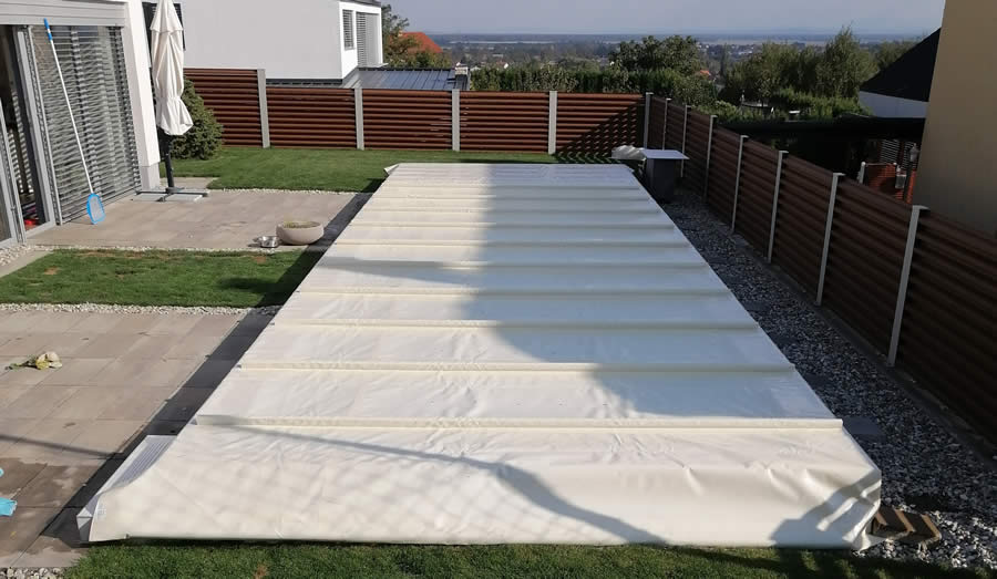 Beige Poolabdeckplane mit Querträgern in Vorbereitung